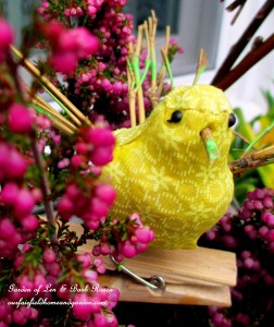 Yellow fabric bird accent sitting in the heather. https://ourfairfieldhomeandgarden.com/diy-project-welcome-spring-time-to-change-the-window-boxes/