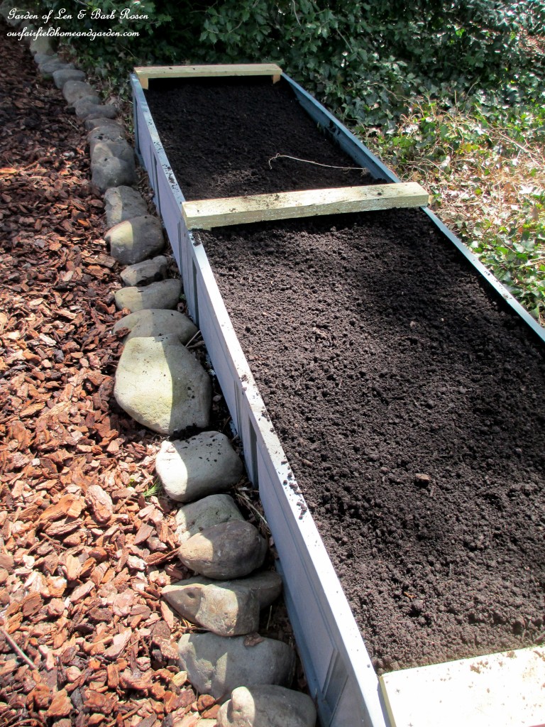 finished and filled, an unpainted raised bed https://ourfairfieldhomeandgarden.com/diy-project-raised-beds-for-free/