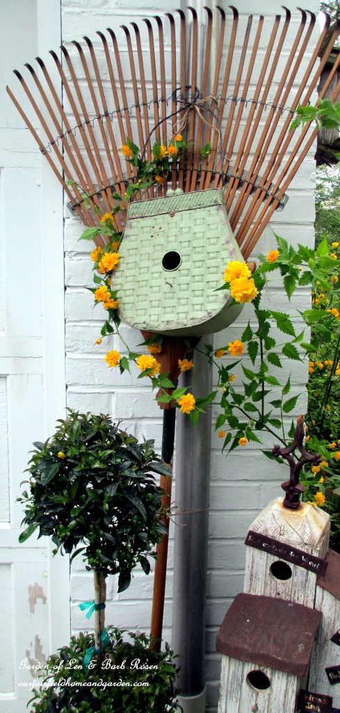 Birdhouse rake by the garage https://ourfairfieldhomeandgarden.com/diy-project-repurposed-rakes/