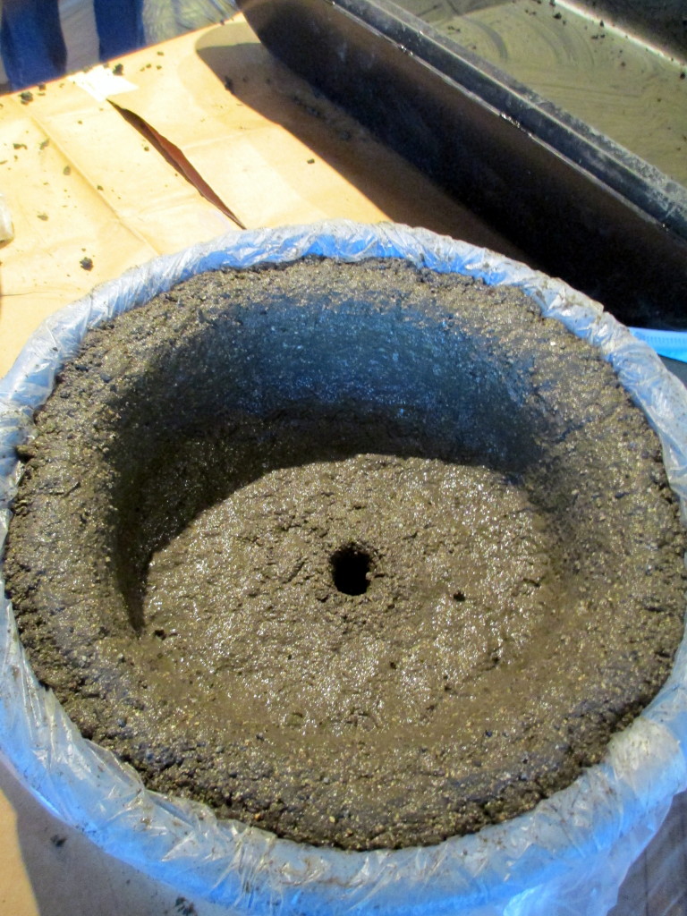 Step # ~ Pat the wet hypertufa mixture firmly onto the bottom and sides of the container. Make a drainage hole in the bottom too!