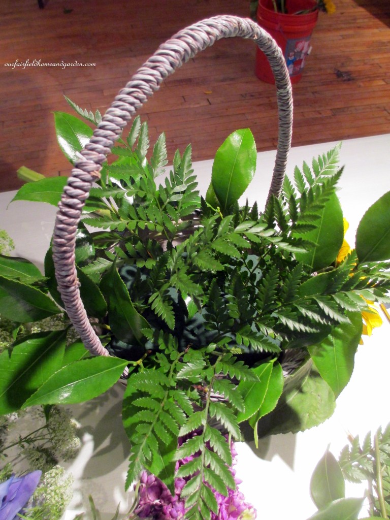 Greens go in first! https://ourfairfieldhomeandgarden.com/diy-project-country-flower-basket/