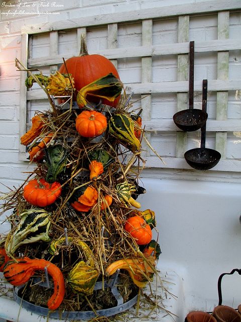 Gourd Tower ~ hay & gourds fill a metal bottle rack https://ourfairfieldhomeandgarden.com/autumn-garden-accents-inside-and-out/