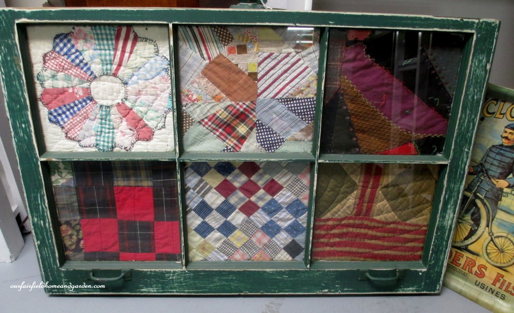 Quilt scraps framed in an old window https://ourfairfieldhomeandgarden.com/recycled-window-picture-frame/